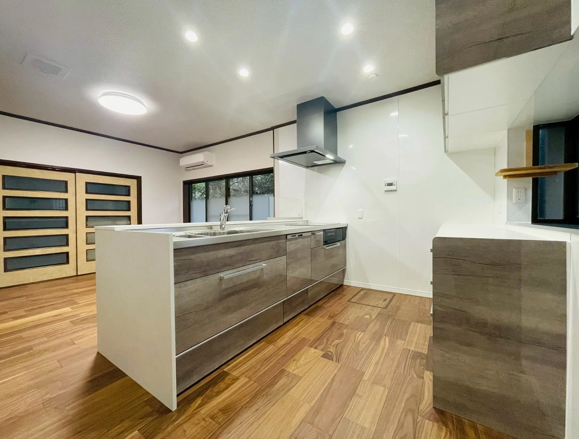 【システムキッチン】クリナップ:ラクエラ間口2,550㎜/扉:グラセウッドグレージュ/デュアルトップ対面カウンター:ホワイトストーン/Jサイドフード:メタルブラック/キッチンパネル:マグネットホワイト